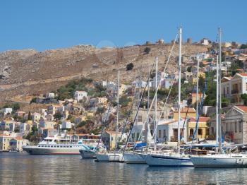 Moorage of Symi town with moored motor boats and yachts, Greece.