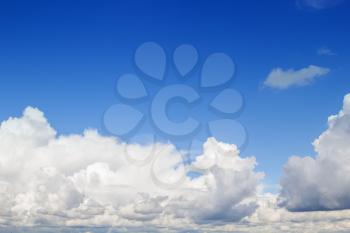 Blue sky with fluffy white clouds background.