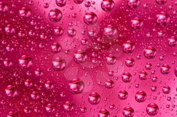 Royalty Free Photo of a Closeup View of Water Drops on a Pink Colored Background
