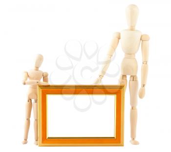 Royalty Free Photo of Two Wooden Mannequins Holding a Picture Frame