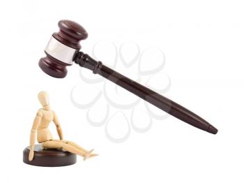 Royalty Free Photo of a Judge's Gavel About to Strike a Wooden Mannequin