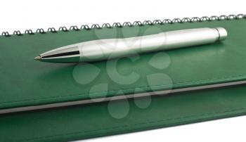 Royalty Free Photo of a Metal Pen Sitting on a Spiral Notebook