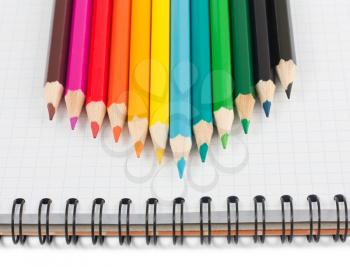 Royalty Free Photo of Coloured Pencils on a Notebook