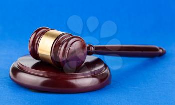 Wooden brown judges gavel on blue background