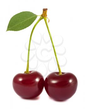 Pair of red cherries with green leaf isolated on white background