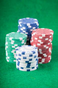 Poker chips on green playing table background