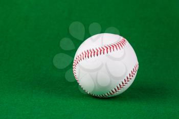 Single white baseball softball on green background