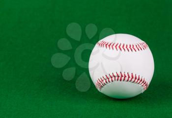 Single white baseball ball on green background