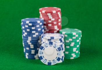 Different casino chips on a green table background