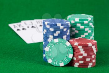 Casino chips and cards on green table background