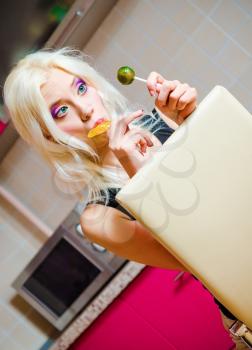Portrait of a beautiful blonde girl with two candies in hands 