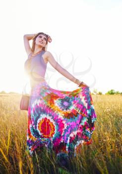 Outdoor portrait of the smiling attractive young boho (hippie) girl in meadow