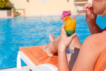 Royalty Free Photo of a Woman Drinking a Cocktail Poolside