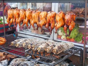 Royalty Free Photo of a Grilled Fish and Hens at a Street Market in Bangkok, Thailand