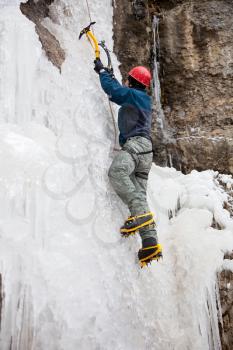 Royalty Free Photo of a Man With Ice Axes Climbing on Ice