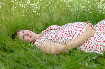 Royalty Free Photo of a Pregnant Woman Laying in Grass