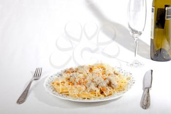 Spaghetti with meat and carrrot on dish, wine glass and bottle isolated on white
