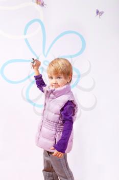Small girl in pink vest with toy airplane isolated on purple background
