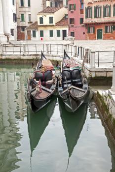 Two gondola in Venice at the pier and buildings