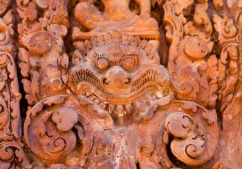 Ancient daemon carving on the wall in temple Banteay Srei, Cambodia
