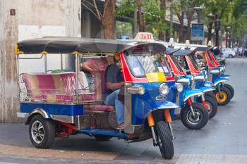 Line of tuktuks with driver on Bangkok street, Thailand
