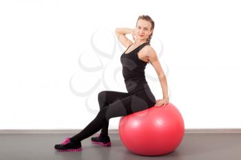 Athletic young woman with red ball isolated on white
