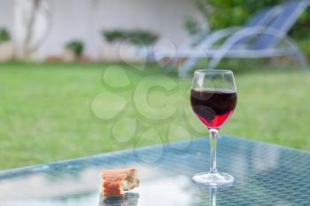 Glass of red wine and bread on the table outdoor
