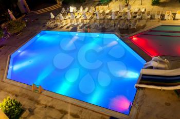 Illuminated swimming pool at night on tropical resort
