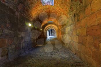 Brick tunnel with light in the end
