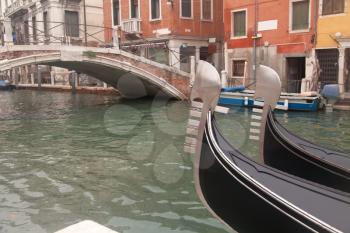 Two gondola in Venice near pier and bridge

