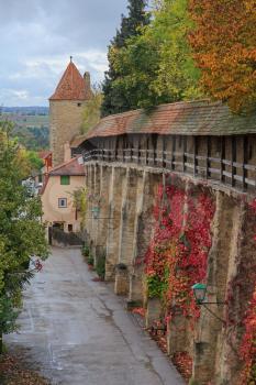 Rothenburg on Tauber castle wall and tower with autumn vines and trees
