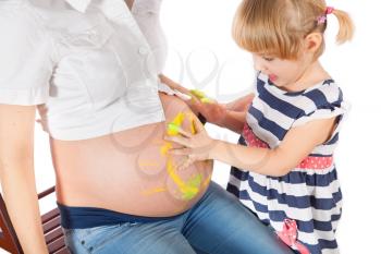 Daughter painting mother's pregnant belly and smiling isolated on white