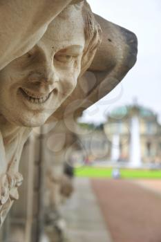 Closeup naked satyr smiling statue crop with fountain and garden at Zwinger palace in Dresden, Germany