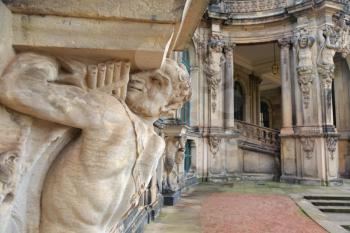 Closeup half naked faunus statue under column with panpipe at Zwinger palace in Dresden, Germany
