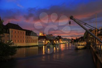 Cloudy sky at sunset, Regnitz river with ships in Bamberg, Germany
