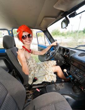 Vintage cheerful girl driving retro car and smiling
