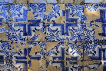 Blue portuguese tiles on the wall with cracks
