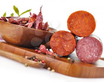 Royalty Free Photo of Pepperoni and Hard Salami With Spices On A Cutting Board