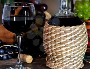 glass of red wine and decorative bottle 