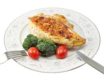 Grilled chicken breast on a plate with fresh vegetables