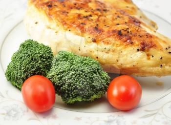 Grilled chicken breast on a plate with fresh vegetables 