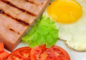 Sliced grilled ham with egg and vegetables, close up