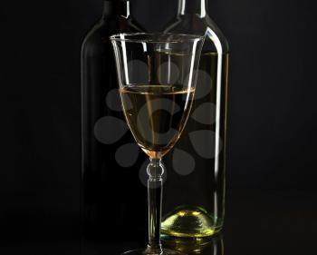 wine glass and bottles on black background