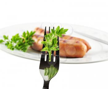 fork with celery and sausages on a plate