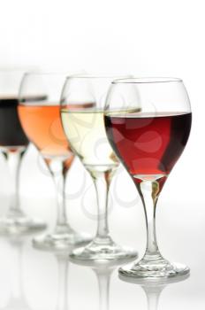 glasses of pink , red  and white wine on white background