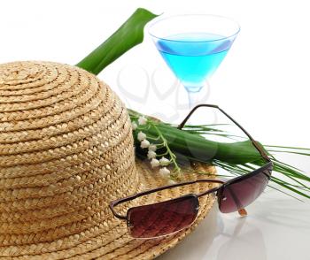 a straw hat with sunglasses , cocktail  and flowers