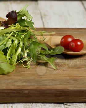 Fresh Salad Leaves And Cherry Tomatoes On A Cutting Board