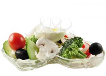a fresh vegetable salad in a glass dish on white background