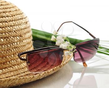a straw hat with sunglasses and flowers