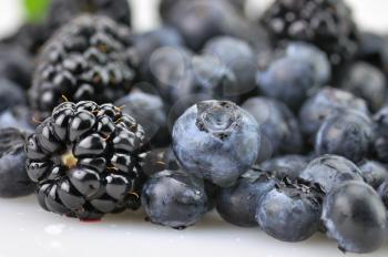 fresh blueberries and blackberries , close up with waterdrops